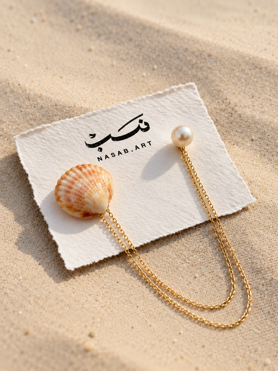 Dana Shell and Pearl Chain Brooch styled on sand